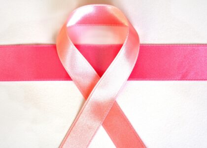 pink breast cancer awareness ribbon on white and pink background